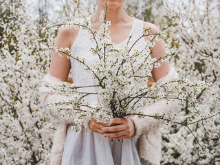 Cute, pretty woman on the background of flowering trees. Concept of rest and relaxation