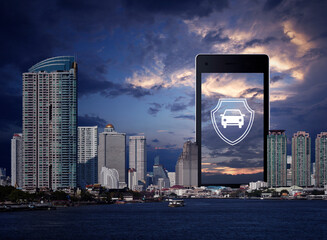 Car with shield flat icon on modern smart mobile phone screen over office city tower, skyscraper, river and sunset sky, Business automobile insurance online concept