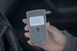 a woman with a breathalyzer in the car, testing for alcohol and drug intoxication of the driver, selective focusing tinted image