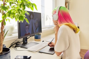 Girl teenager artist in headphones drawing on computer using graphics tablet