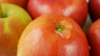 Wall Mural - Many ripe red apples and water drops fall down, slow motion