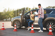 © New Africa - Instructor with clipboard and his student near car outdoors. Driving school exam