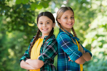 Happy cute girls friends smile in casual fashion style keeping arms crossed summer landscape, friendship