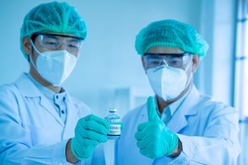 Asian medical scientists wearing PPE protective suit work n laboratory for virus pandemic vaccine