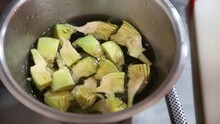 A Metal Bowl With Artichokes Peeled In Water. Washing Artichokes In Water Before Cooking. Freshly Picked Artichokes

