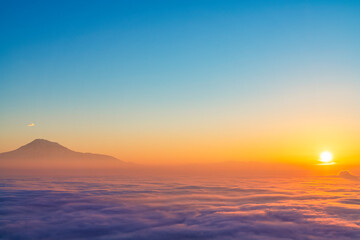 Beautiful sunset with long exposure clouds. The mountains in a clouds and fog. Ararat mountain.