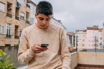 Wall Mural - young teenager with mobile phone on the terrace of the building