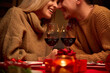 © insta_photos - Happy couple in love celebrate Valentines day dining at home, in restaurant, having date with candles, red wine in glasses sit at romantic setting table, close up view. Valentines day on February 14