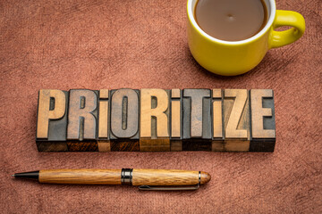 Wall Mural - prioritize - motivational word abstract in vintage letterpress wood type with a cup of coffee, business or lifestyle concept