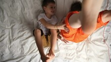 Brothers Having Fun, Funny Workout In Bed. Happy Little Boys Doing Exercises And Fooling Around. Top View.