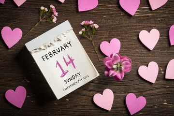 tear-off calendar with Valentine's Day 2021 and heart decoration on top on wooden background