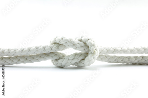 Obraz Dibond Close-up Of Tied Knot On Rope Against White Background