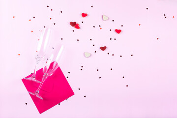 Wall Mural - Word love, heart shaped sweets, confetti and glasses of champagne on white background.