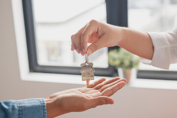 Close up hand of home, apartment agent, realtor was holding the key to the new landlord, tenant or rental.After the banker has approved and signed the purchase agreement successfully.Property concept.