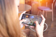 © witsawat - Asian girl are playing the mobile game with blurred on screen at home. The hand is touch screen for play game in the smartphone with clipping path.