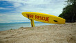 © Nicolas Gregor - Yellow surfboard on beach with red text surf rescue emergency on a beach