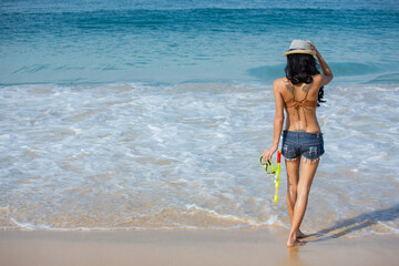 Wall Mural - Asian woman are sitting on the beach While relaxing on vacation for the weekend on sunny days and nice weather in travel and holiday concept.