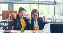 Happy Success Business Woman Partner Working Together In Company Office Corporate Executive Teamwork. Meeting Executive Asian Business Woman Using Laptop Office Desk With Fist Arm Raised Win Happiness