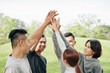 © DragonImages - Cheerful young Asian people giving each other high five after finishing training outdoors