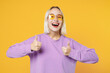 © ViDi Studio - Smiling fun young blonde caucasian woman 20s bob haircut bright makeup wearing basic casual purple shirt and glasses showing thumbs up looking camera isolated on yellow background studio portrait