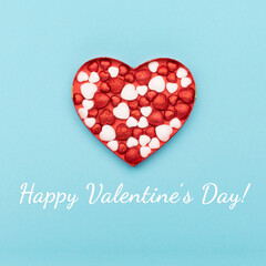 Red white glitter hearts on blue paper background. Happy Valentines Day concept.