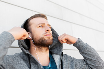 Wall Mural - fitness, sport and lifestyle concept - young man in earphones listening to music outdoors