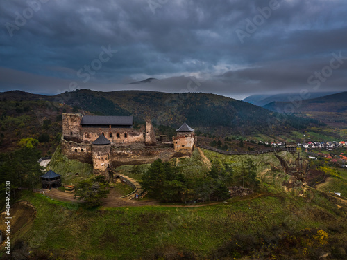 Fototapeta Boldogko, Hungary - Aerial panoramic view of Boldogko Castle (Boldogko vara/Boldogkovaralja) at autumn season with Zemplen Mountains at the background at sunset with blue sky and clouds