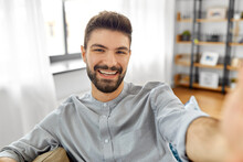 Technology, People And Lifestyle Concept - Happy Man Taking Selfie Or Having Video Call At Home