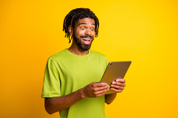 Wall Mural - Photo of young man use modern device tablet read surprised excited news information isolated over yellow color background