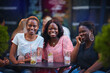 © Olesia Bilkei - happy african american women, students having fun in summer cafe