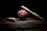 Fototapeta Zwierzęta - Cricket ball and bails still life close-up on a highly texture wooden surface. 