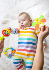 Poster - The mother gives a rattle to the baby. Selective focus.