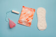 menstruation products, intimate hygiene and protection, sanitary pads, tampon and menstruation cup on blue background