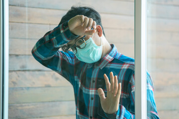 Wall Mural - Man wearing protective mask to Protect Against Covid-19 staying at home and worried about covid-19 pandemic,Coronavirus has turned into a global emergency.