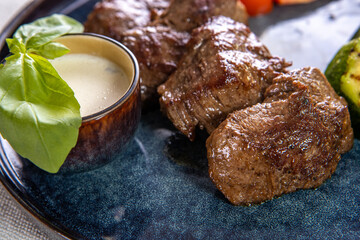 Grilled meat in a plate with stewed vegetables close up