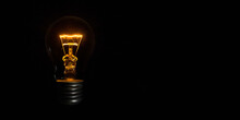 Incandescent Light Bulb On Black Background