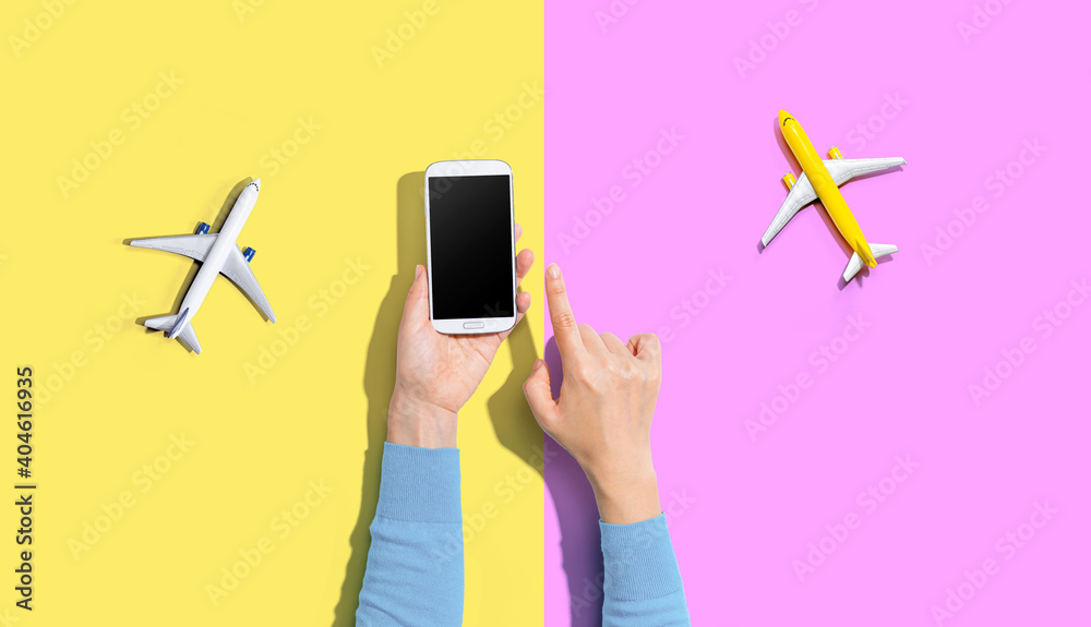 Person holding a smart phone with airplanes from above - obrazy, fototapety, plakaty 