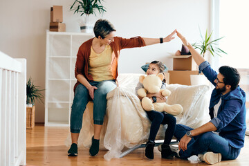 Wall Mural - Happy family having fun while moving into their new home.