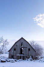 Old Weathered Barn On Snow Covered Midwest Farm At Sunrise