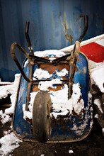 Snow On Abandoned Upside Down Wheelbarrow