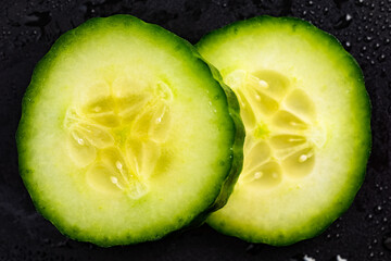 Wall Mural - Cucumber slices isolated on closup details. Moisturising concept