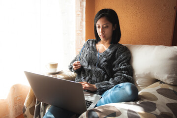 A young woman using her laptop at home