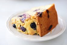 Close-up Of Blueberry Cake Slice In Plate On White Table