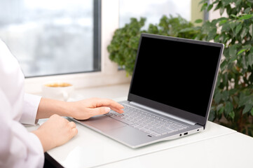 Poster - mocup laptop. Hand using laptop with blank black screen at home office. Laptop Computer Notebook Concept
