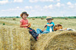 © fisher05 - Happy children having breakfast with milk and bread in the countryside sitting on a wheat stack Happy childhood concept