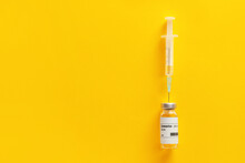 Vaccine For Immunization Against COVID-19 And Syringe On Color Background