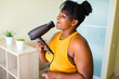 © yurakrasil - beautiful afro woman drying hairs and singing like a microphone