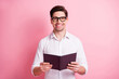 © deagreez - Portrait of optimistic guy hold book wear spectacles white shirt isolated on pink color background