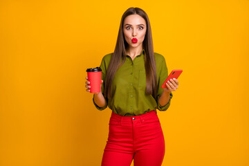 Wall Mural - Portrait of pretty coquettish straight-haired girl drinking latte sending air kiss using cell 5g isolated over bright yellow color background