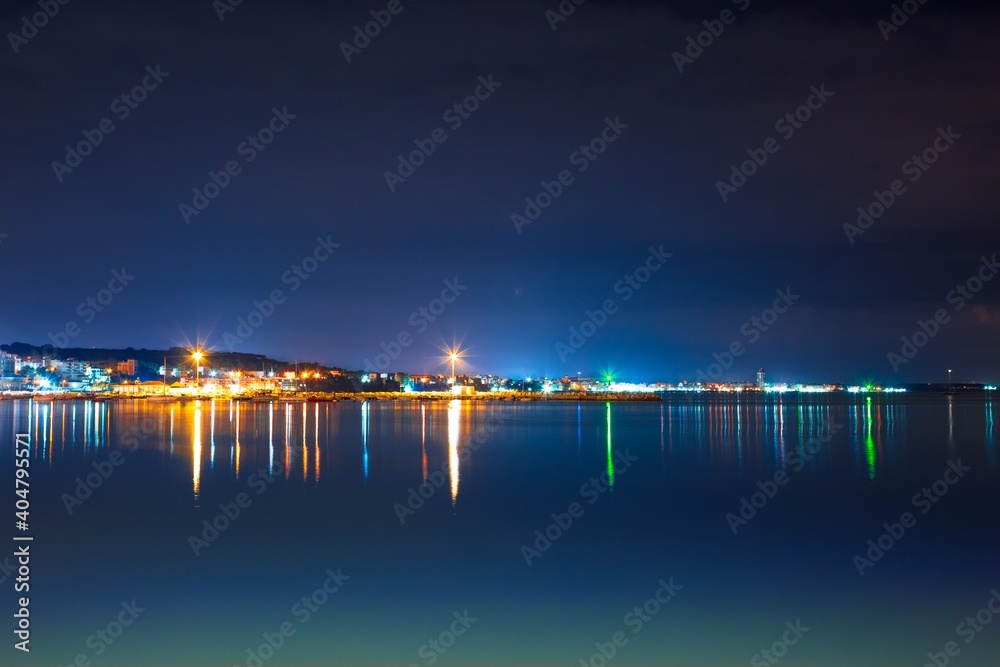 Illuminated City By Sea Against Clear Sky At Night - obrazy, fototapety, plakaty 